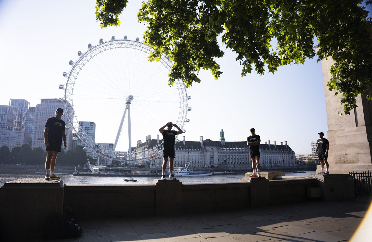 Three Ordinary Mile Club runners on the Thames embankment wall with the London Eye behind them, planning a parkrun tourism trip