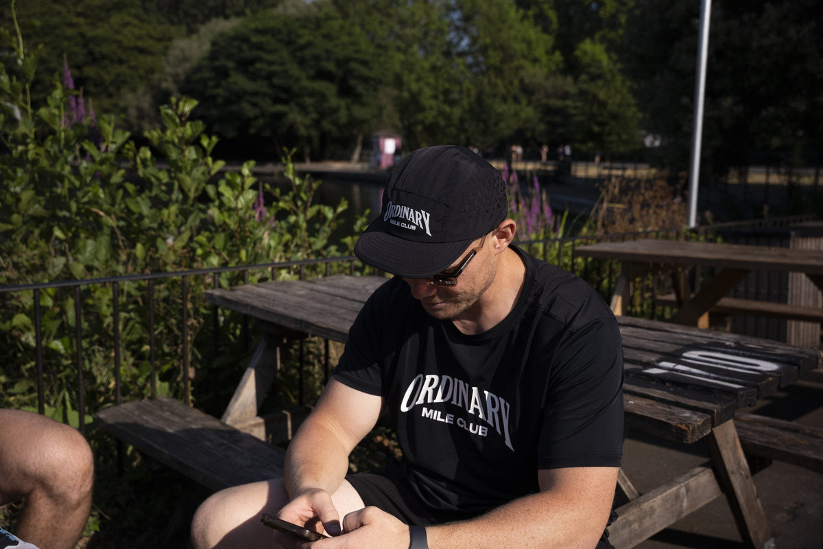 Runners in Ordinary Mile Club kit at a café table after a run in Warwickshire