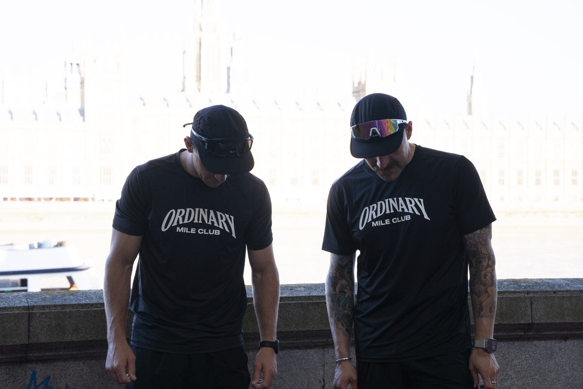 Two runners pacing a long marathon training run together along the Thames in London